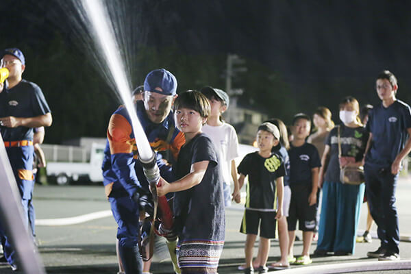 消防団員と一緒に放水大変をする子どもの様子